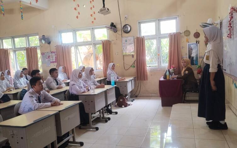 Wali Kelas 9.7 SMP Negeri 19 Palembang, Ruly Agustina, S.Pd., M.M., memberikan pengarahan kepada peserta didik pada hari pertama masuk sekolah Tahun Pelajaran 2026/2027.